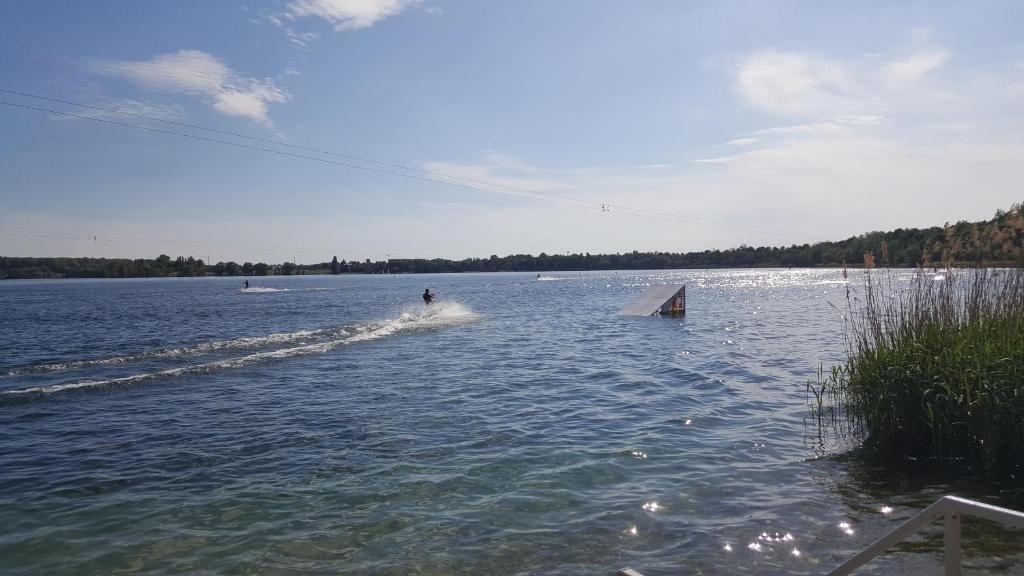 une personne fait du ski nautique sur un lac dans l'établissement FeWo am Kulkwitzer See, à Leipzig