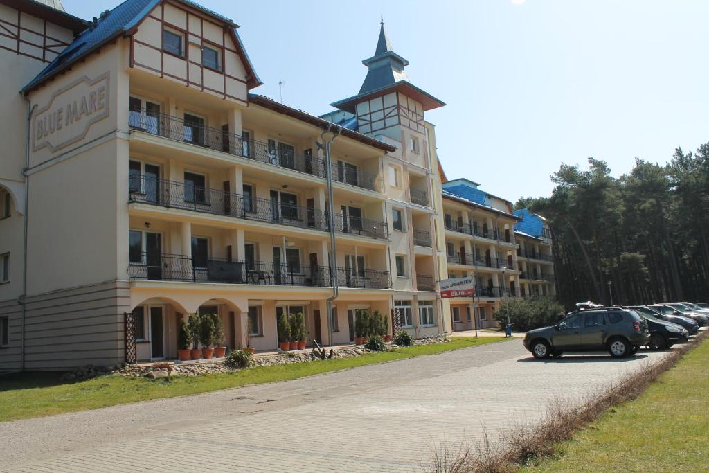 budynek z zaparkowanym przed nim samochodem w obiekcie Apartament "Zacisze" w Łukęcinie