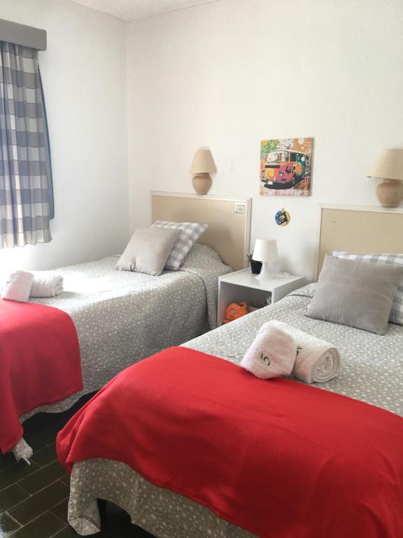a bedroom with two beds with red sheets at Villa Quica, heated pool in Albufeira