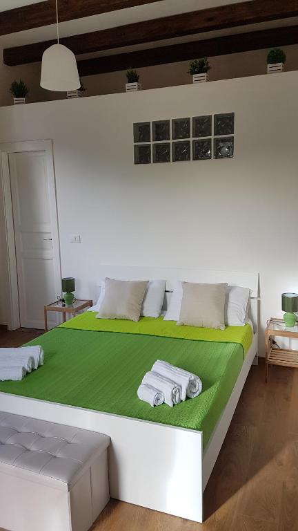 モンデッロにあるMondello Sicily Roomsの大型ベッド(緑のシーツ、タオル付)