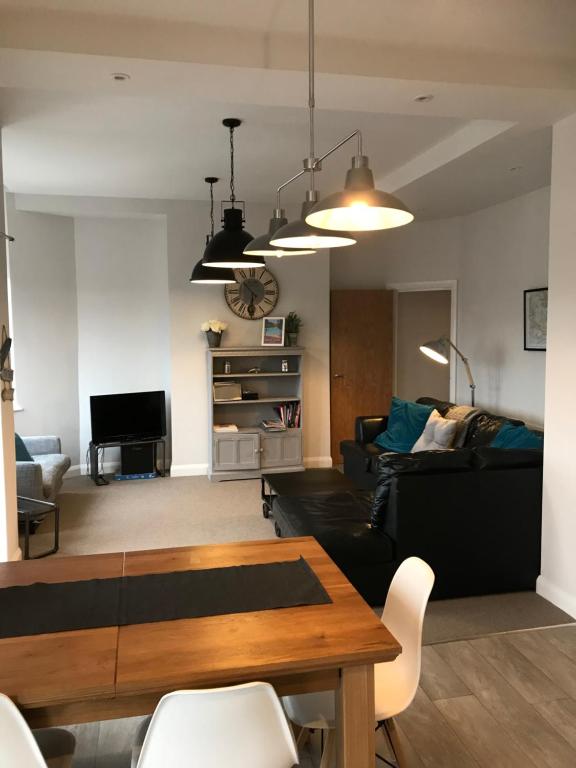 ein Wohnzimmer mit einem Sofa und einem Tisch in der Unterkunft Wight view, flat 2 rosslyn house in Swanage