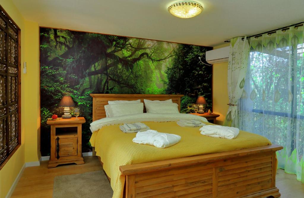 1 dormitorio con 1 cama con toallas en The Rose Trail, en Kefar Weradim