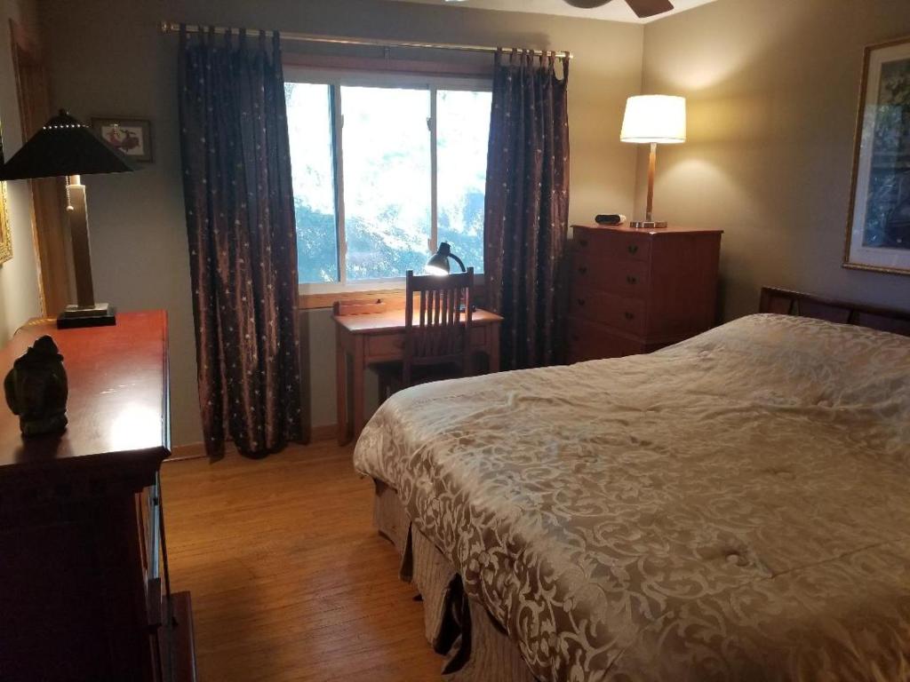 a bedroom with a bed and a desk and a window at Beautiful Views on Golf Course in Kingston