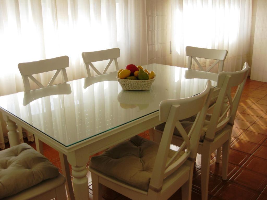 a table with chairs and a bowl of fruit on it at Apartamentos Turisticos Arosa Ogrove in O Grove