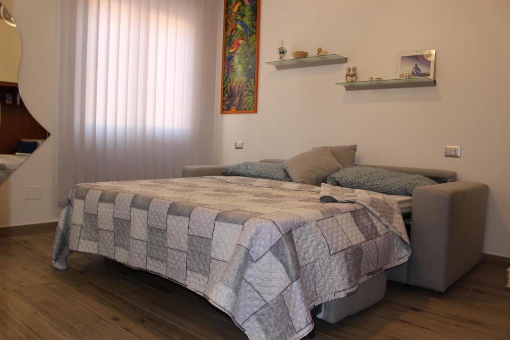 um quarto com uma cama e um sofá em Sissi B&B em Pozzuoli