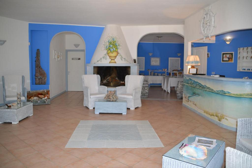 a living room with blue walls and a fireplace at Hotel Il Timone in Cugnana