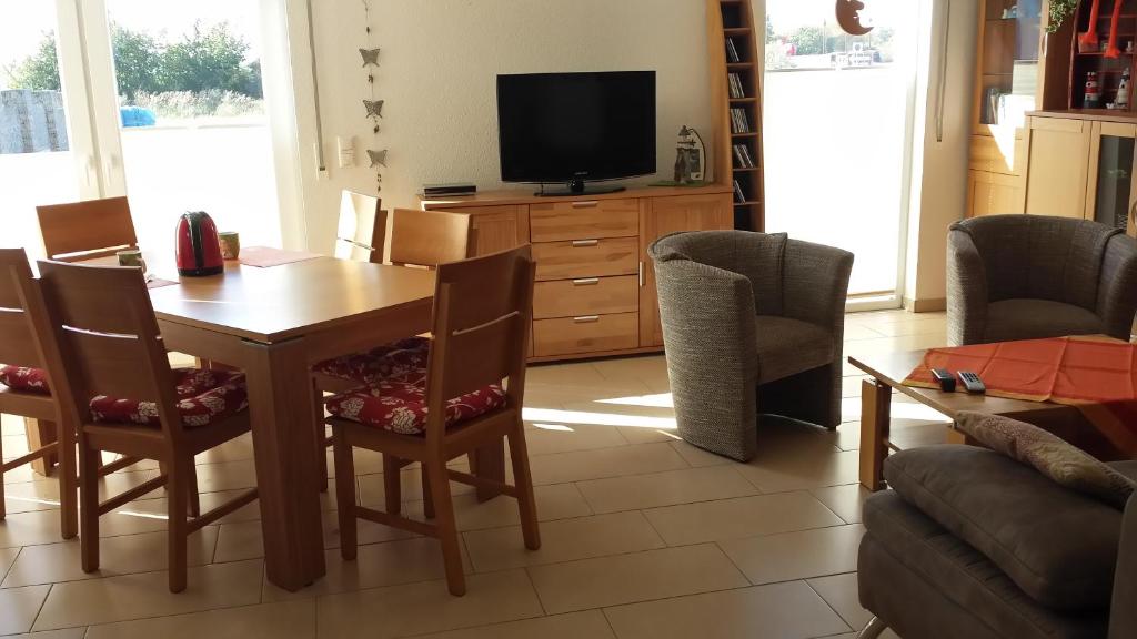 uma sala de estar com uma mesa e cadeiras e uma televisão em Haus am Leuchtfeuer A em Peenemünde
