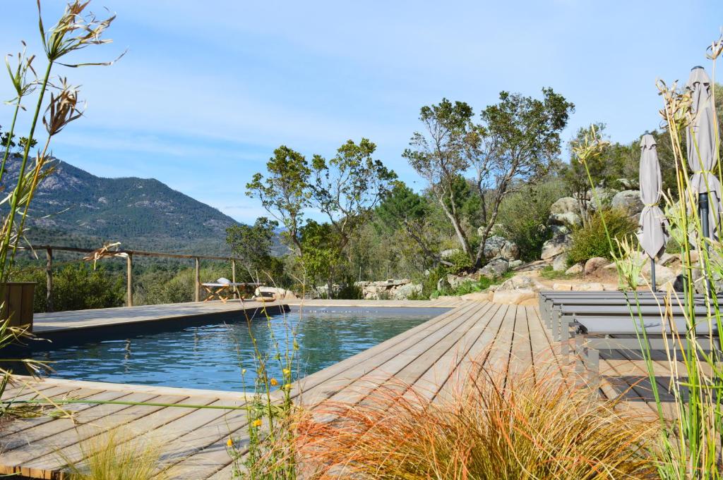 a swimming pool with a mountain in the background at Les Petites Maisons in Sotta