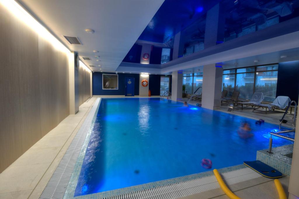a large pool with blue water in a hotel room at Celma Condohotel Old Town Gdańsk in Gdańsk