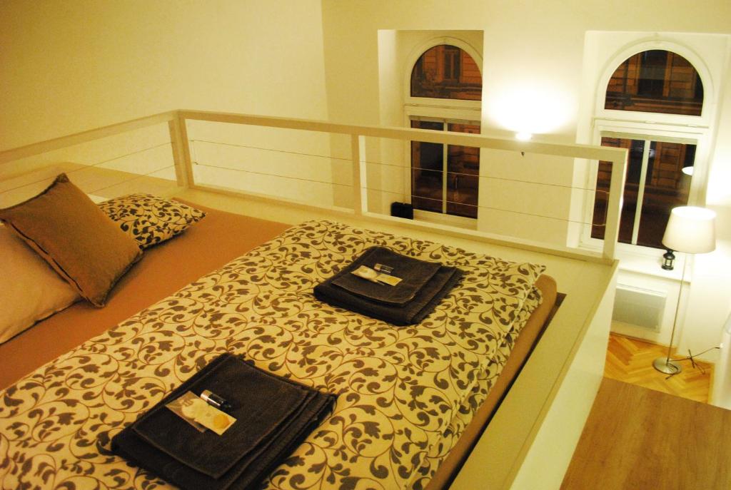 1 dormitorio con 1 cama con 2 toallas en Apartments Centre in Style, en Olomouc