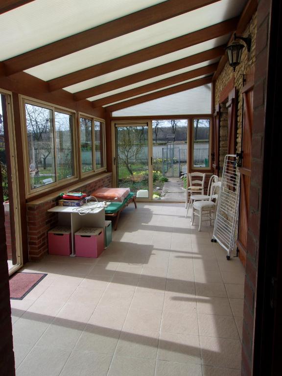 a screened in porch with a ceiling with windows at Gîte à la campagne in Cressonsacq