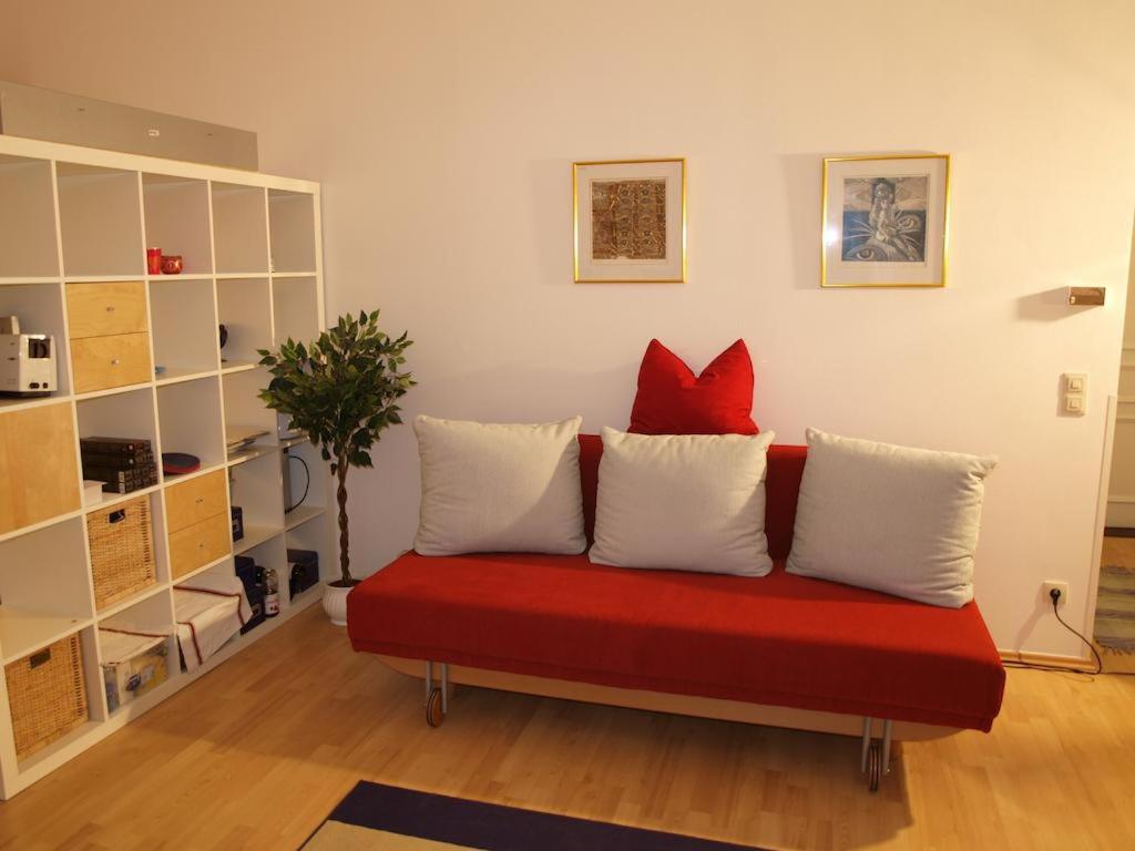 バードガシュタインにあるExecutive Apartment 2の赤いソファに座った赤い枕2つ(1室につき)