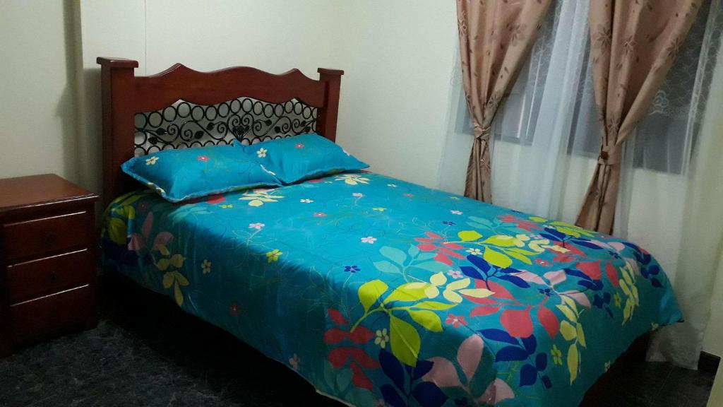 1 dormitorio con 1 cama con edredón azul en Torres del rio, en Armenia