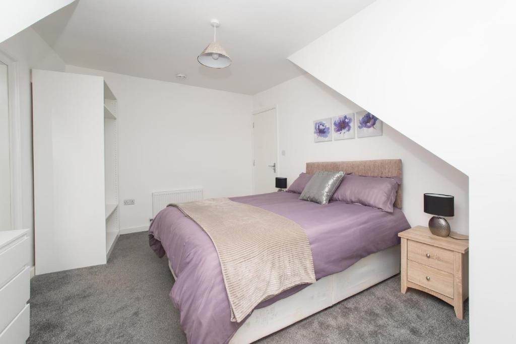 Hylton Road في سندرلاند: غرفة نوم بيضاء مع سرير وموقف ليلي