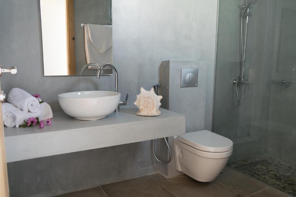 a bathroom with a sink and a toilet and a shower at Bali Diamond "by Checkin" Adults Only in Bali