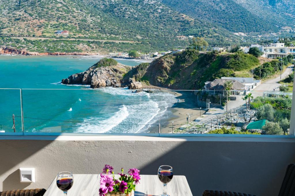 a table with wine glasses and a view of a beach at Bali Diamond "by Checkin" Adults Only in Bali