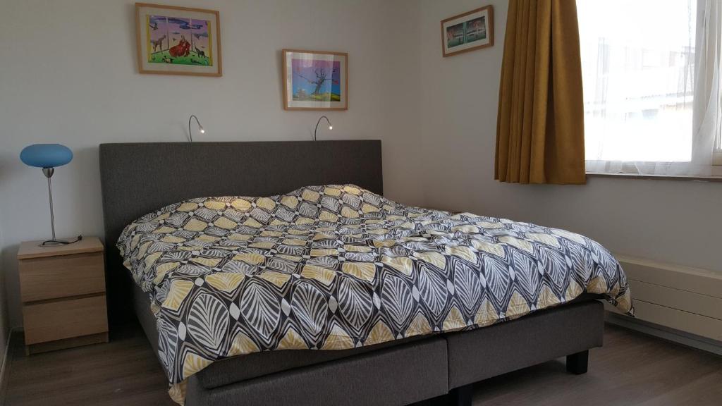 Un dormitorio con una cama con una colcha encima en Quiet spacious room, en Ámsterdam