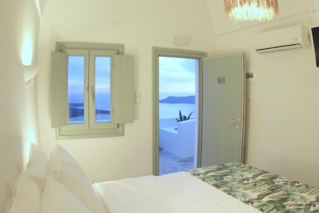 a bedroom with a bed and a window at Agave Santorini Design Boutique Hotel in Imerovigli