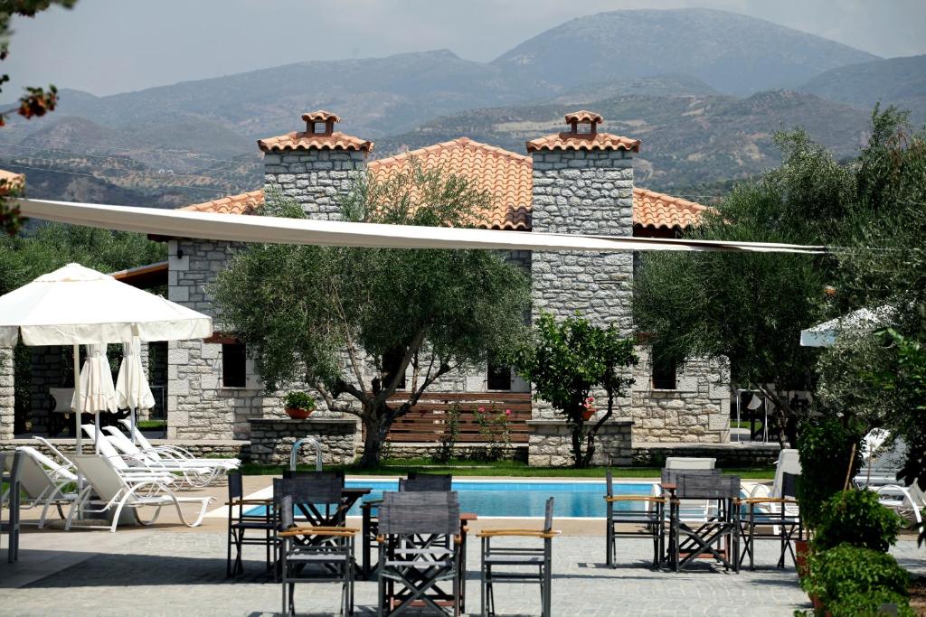 a group of chairs and a pool in front of a house at Asfendamos in Kakovatos