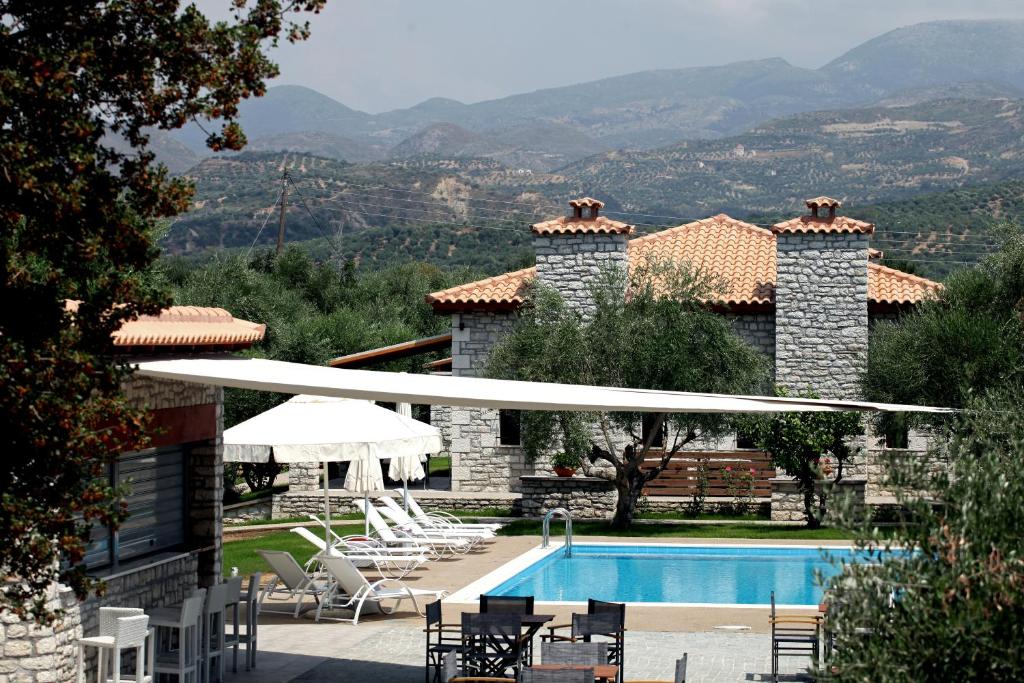 a villa with a swimming pool and mountains in the background at Asfendamos in Zacharo