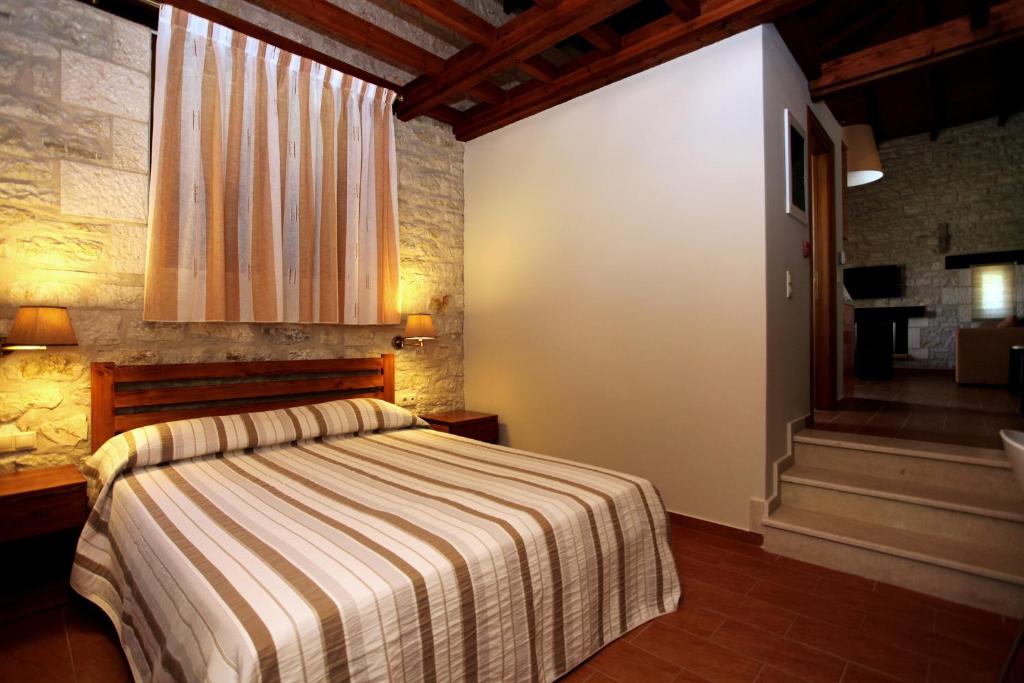 a bedroom with a bed with a striped blanket at Asfendamos in Zakharo