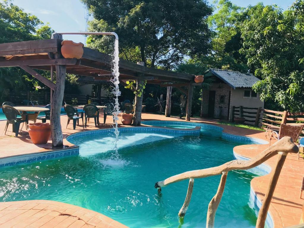 a swimming pool with a water fountain at Fazenda San Francisco in Pôrto
