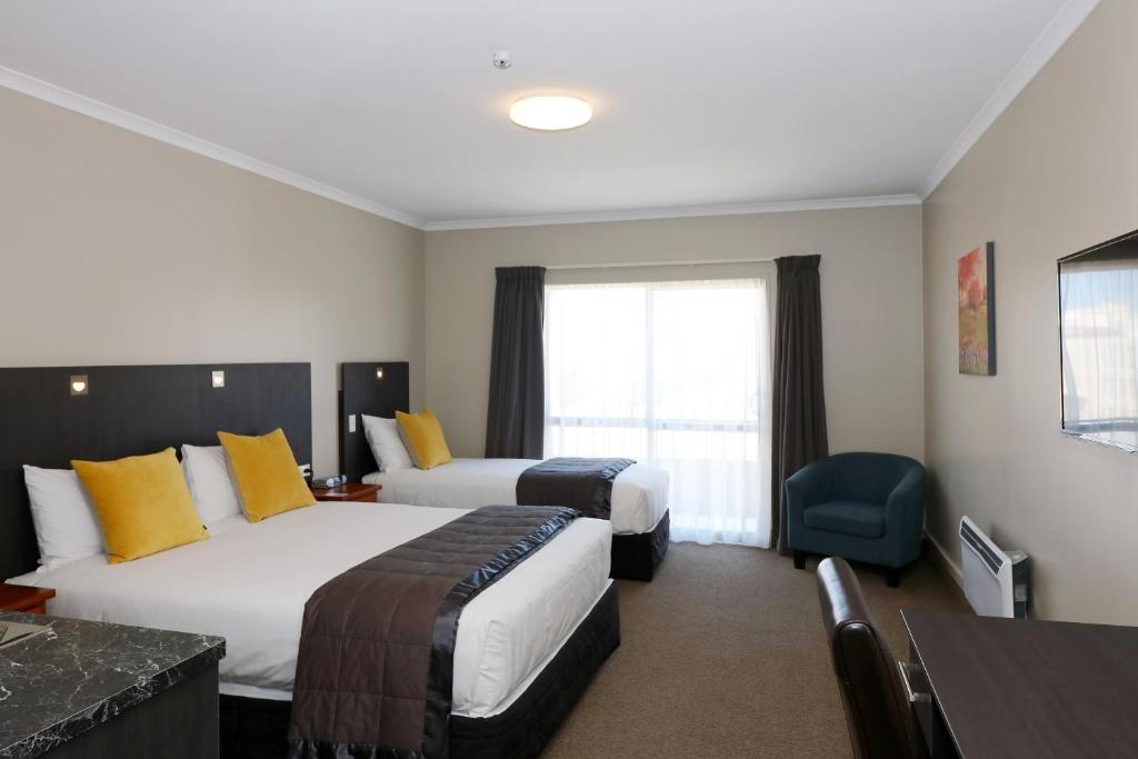 Postel nebo postele na pokoji v ubytování The Victoria Hotel Dunedin
