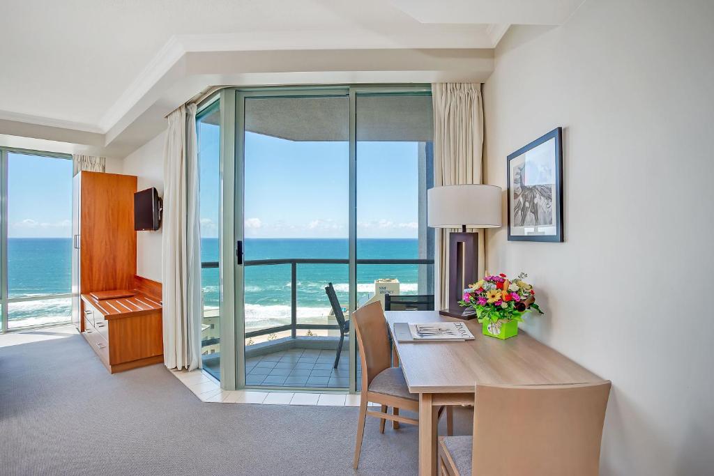 a room with a table with a view of the ocean at Mantra Legends Hotel in Gold Coast