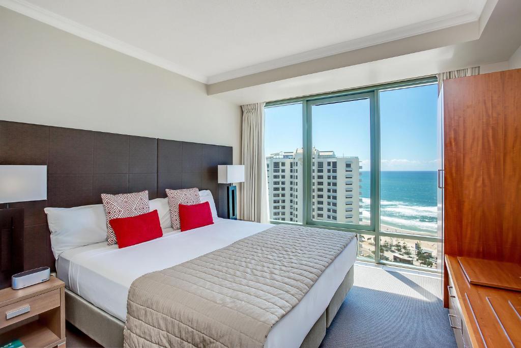 a bedroom with a bed and a large window with the ocean at Mantra Legends Hotel in Gold Coast