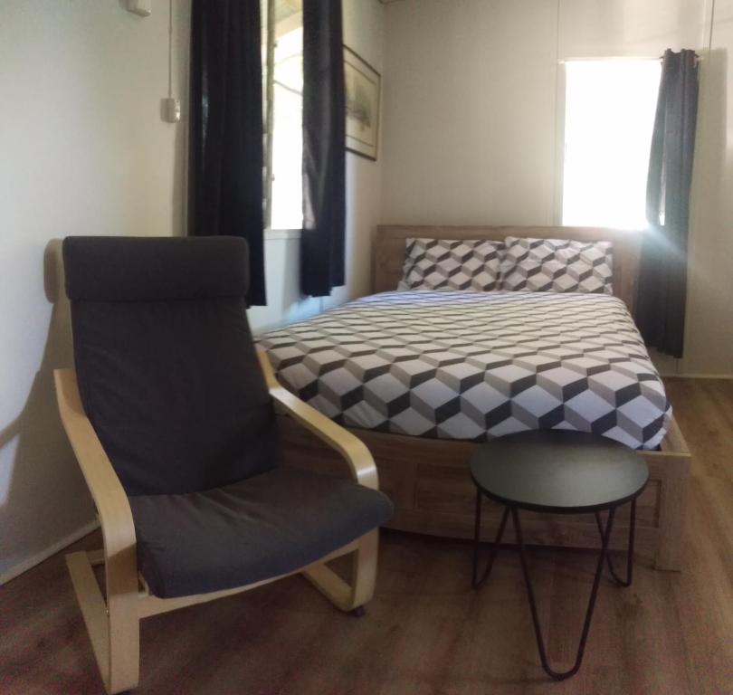 
a bed room with a chair and a desk at Pentland Hotel Motel in Pentland
