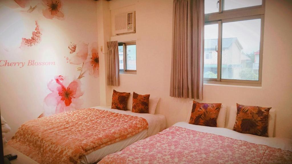 Guiju Lin Garden Homestay في نانزوانج: غرفة نوم بسريرين ونافذة