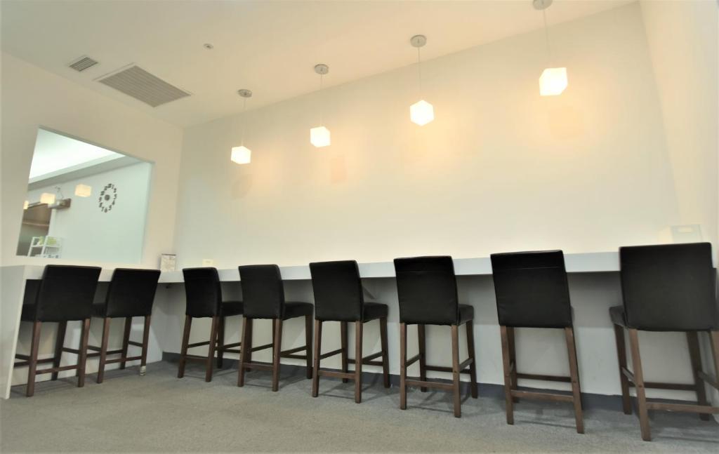 a row of black chairs in a waiting room at Inn Cube - Ximen in Taipei