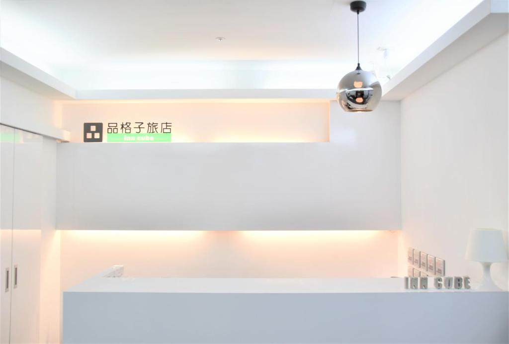 a white kitchen with a light hanging from the ceiling at Inn Cube - Ximen in Taipei