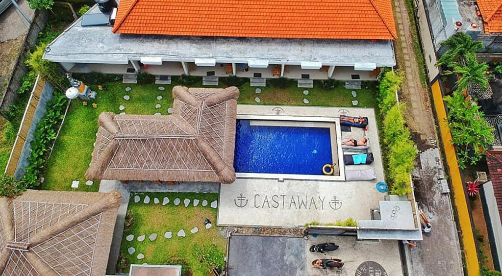 een uitzicht op een zwembad in de achtertuin bij Castaway Hostel in Canggu