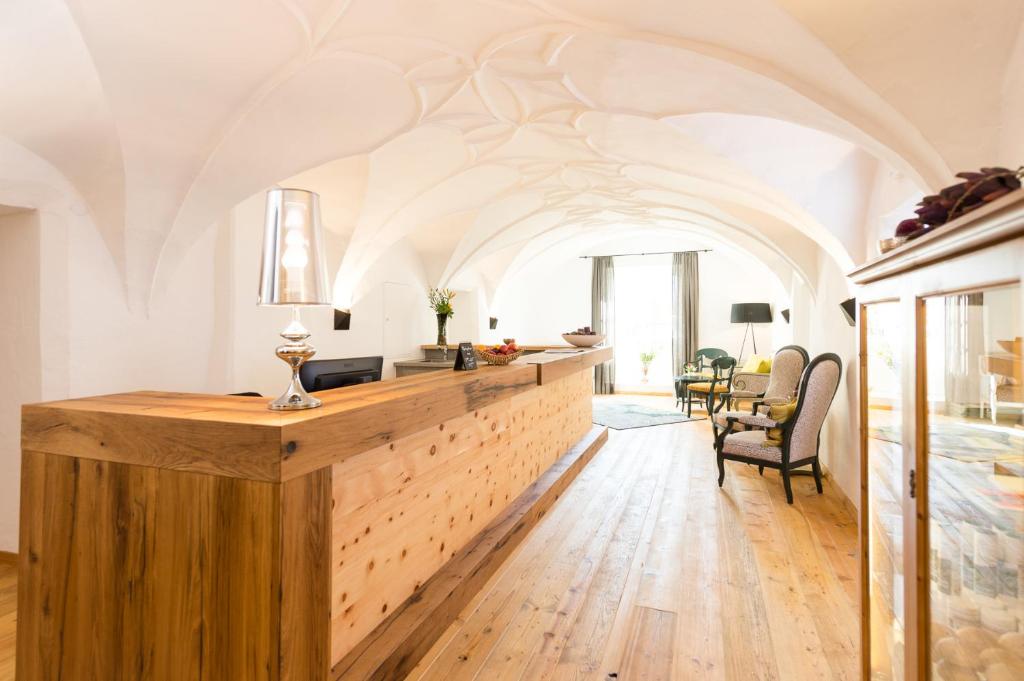 a living room with a wooden counter and a dining room at Hotel die Hindenburg in Saalfelden am Steinernen Meer