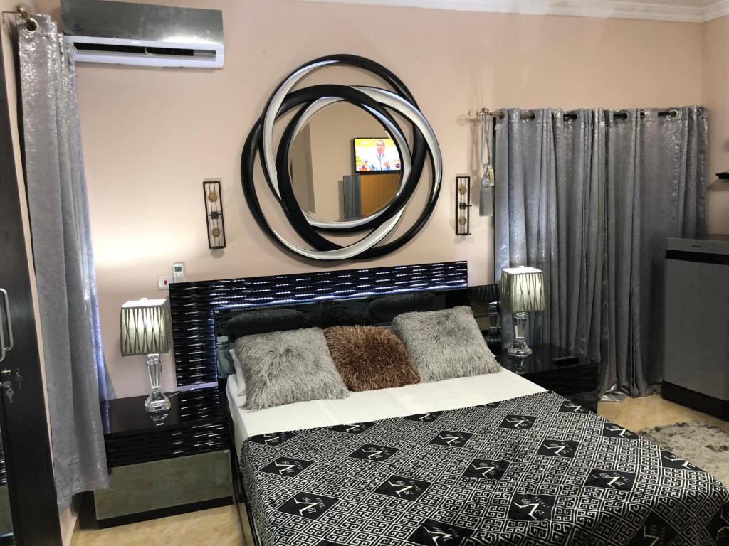 1 dormitorio con cama y espejo grande en Westland Villa en Accra