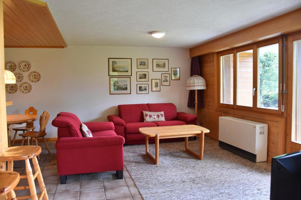 uma sala de estar com um sofá vermelho e uma mesa em Botzatei 001 em Verbier