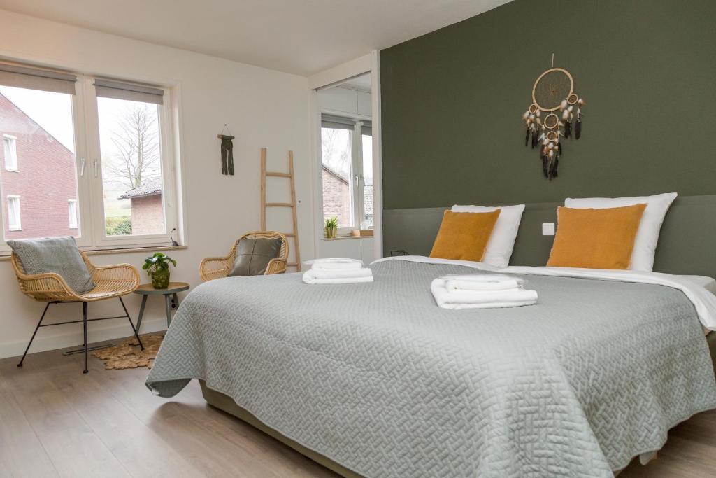 1 dormitorio con 1 cama grande y 2 toallas. en Hotel - Restaurant De 4 Jaargetijden en Epen