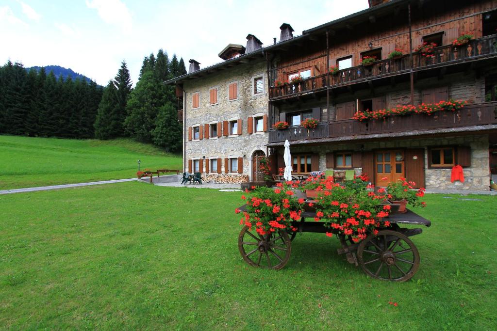 a horse drawn cart with flowers in front of a building at Haus Khlemele in Sauris