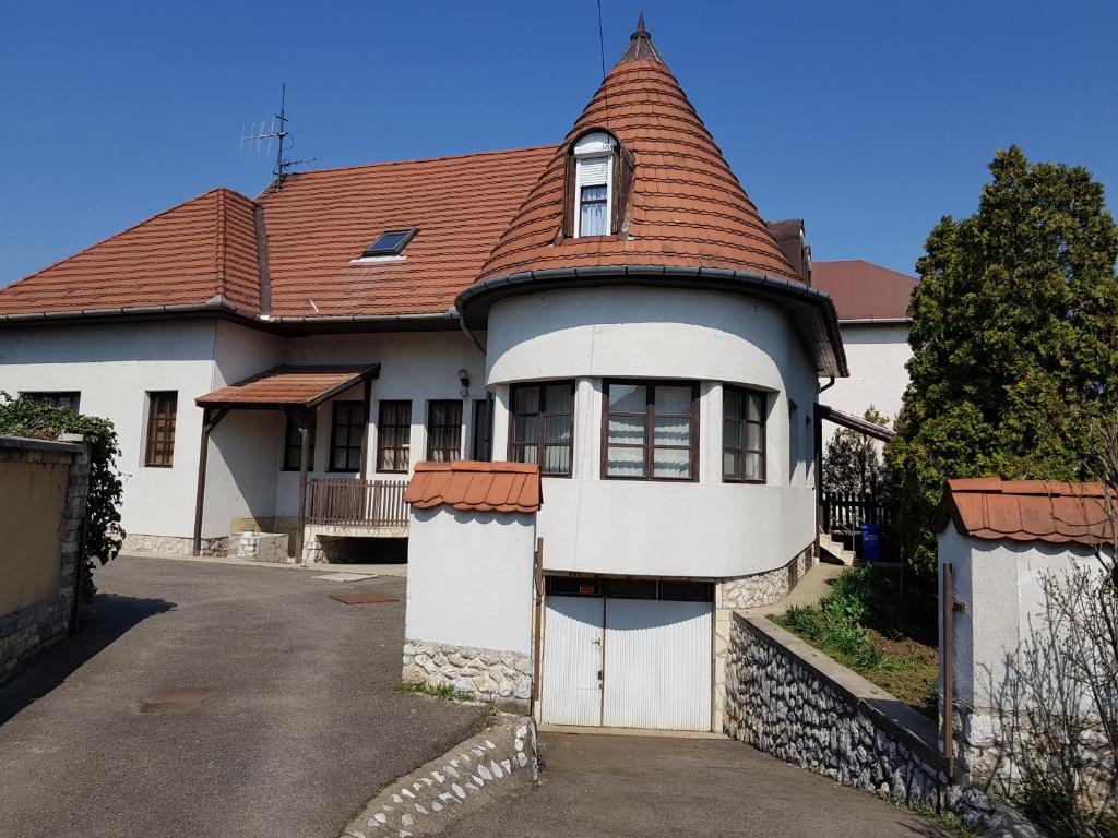 a large white house with a red roof at La Boheme Apartman in Miskolc