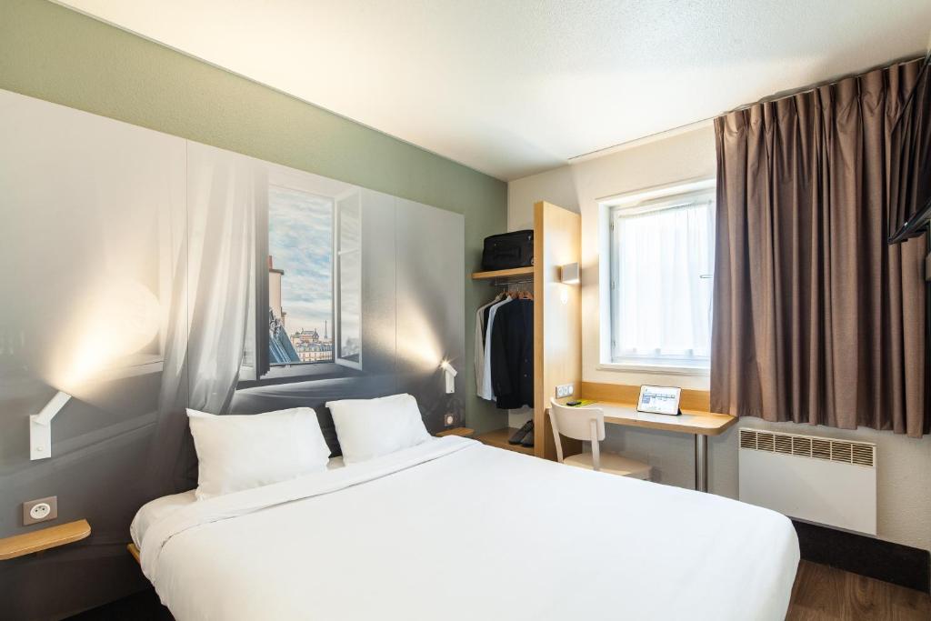 Habitación de hotel con cama y ventana en B&B HOTEL Evry Lisses 1, en Lisses
