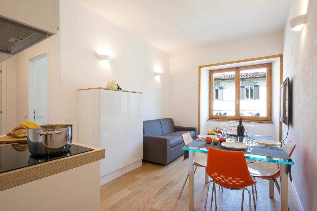 cocina y sala de estar con mesa y sillas en Alinari Apartment, en Florencia