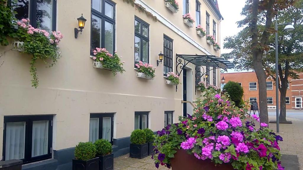 un edificio con flores a un lado. en Park Hotel en Frederikshavn