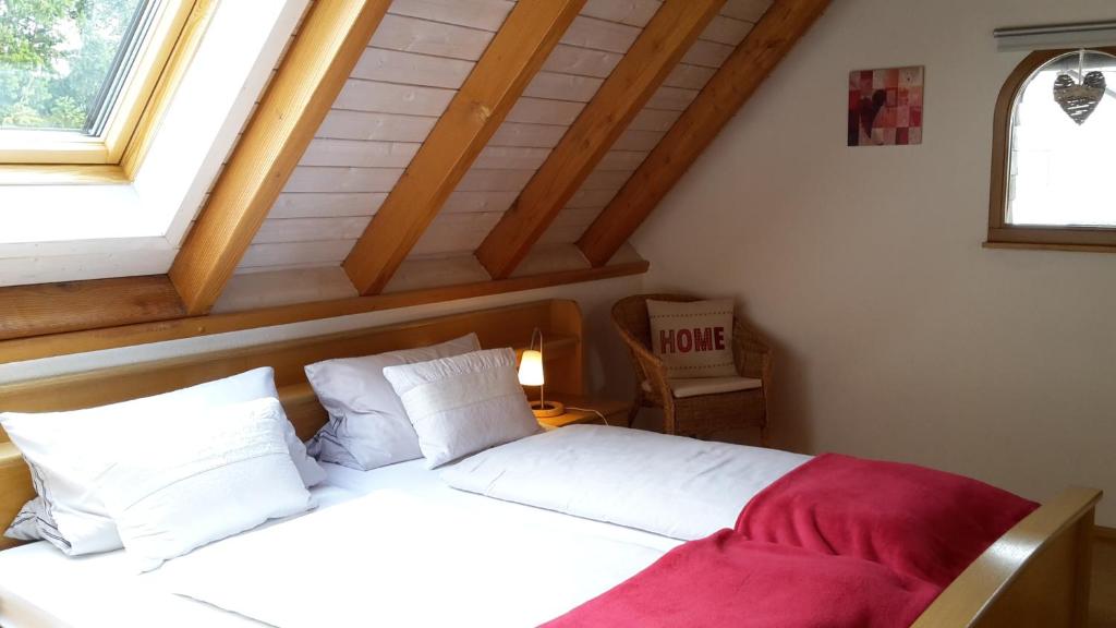 a bedroom with a bed with white sheets and a window at Ferienwohnung Hasenfratz in Löffingen