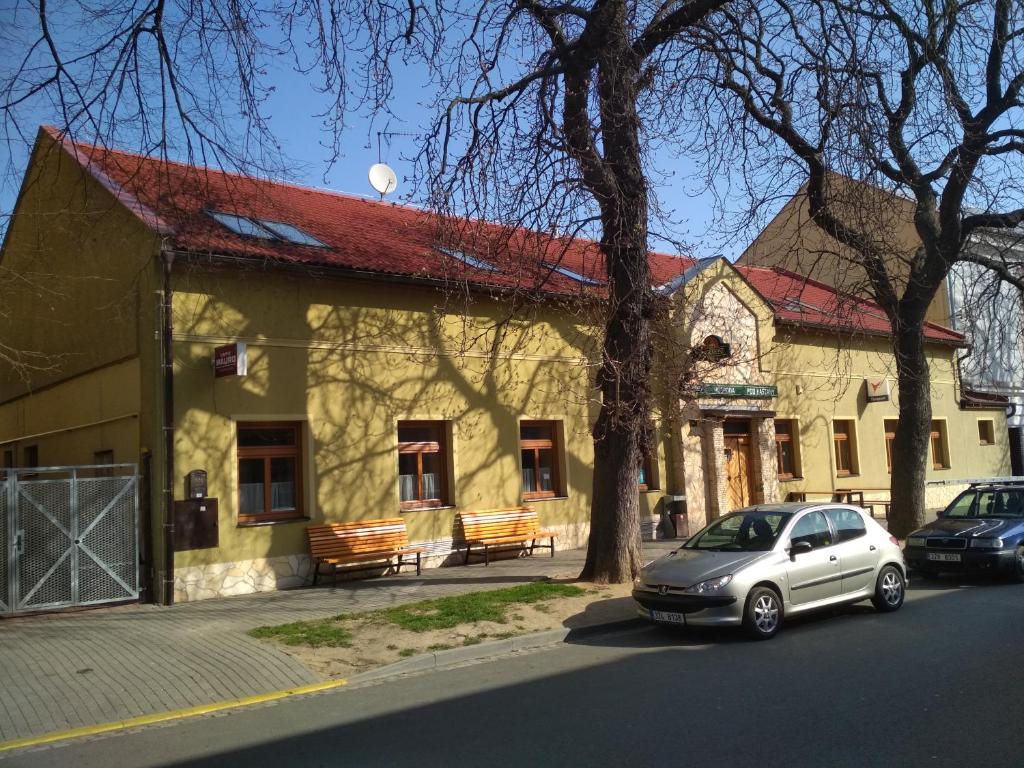 a white car parked in front of a building at Penzion Pod Kaštany Kvasice in Kvasice