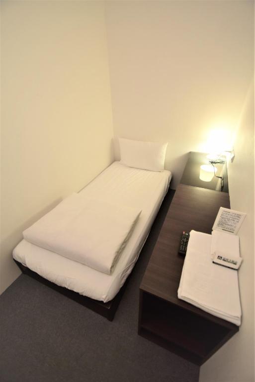 a small room with a bed and a desk at Inn Cube - Ximen in Taipei