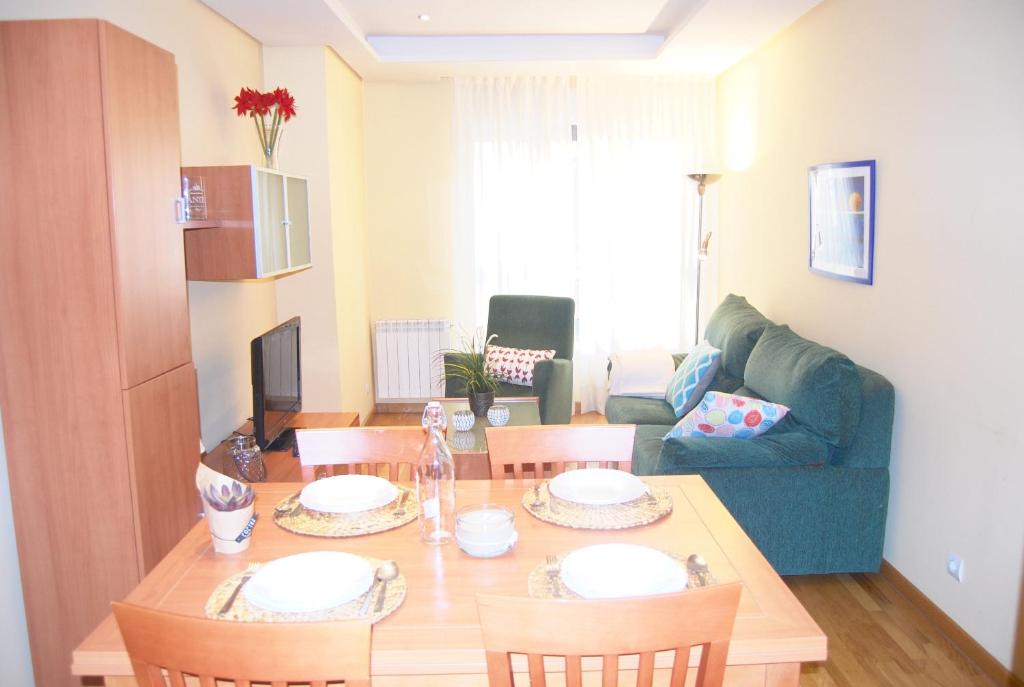 uma sala de estar com uma mesa e um sofá em Apartamentos Turisticos ARCH em León