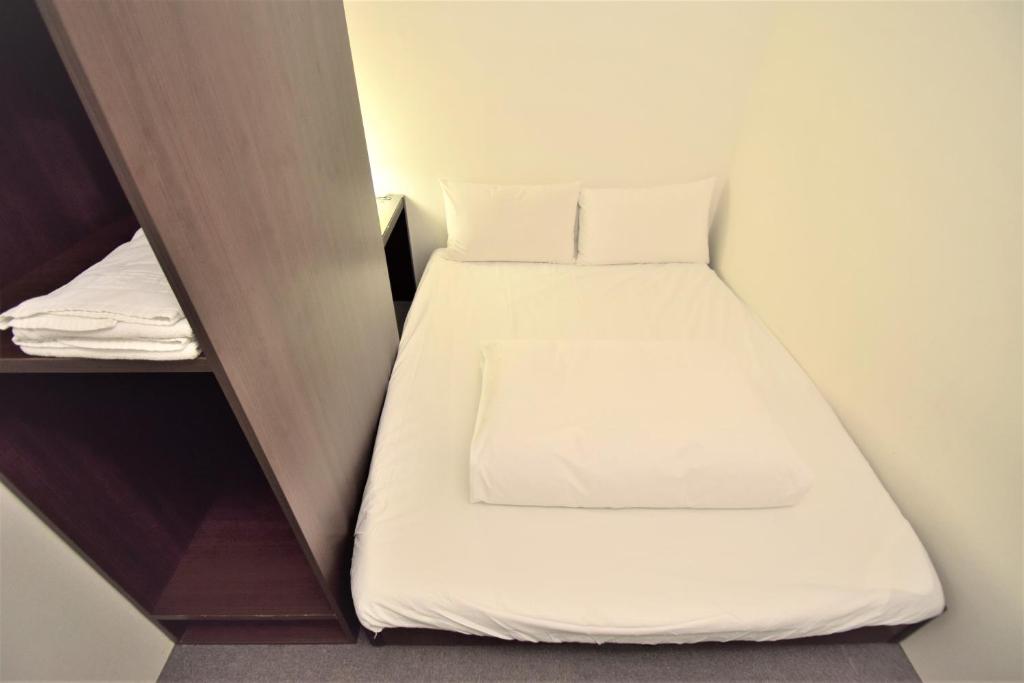 a small bedroom with a bed in a small room at Inn Cube - Ximen in Taipei
