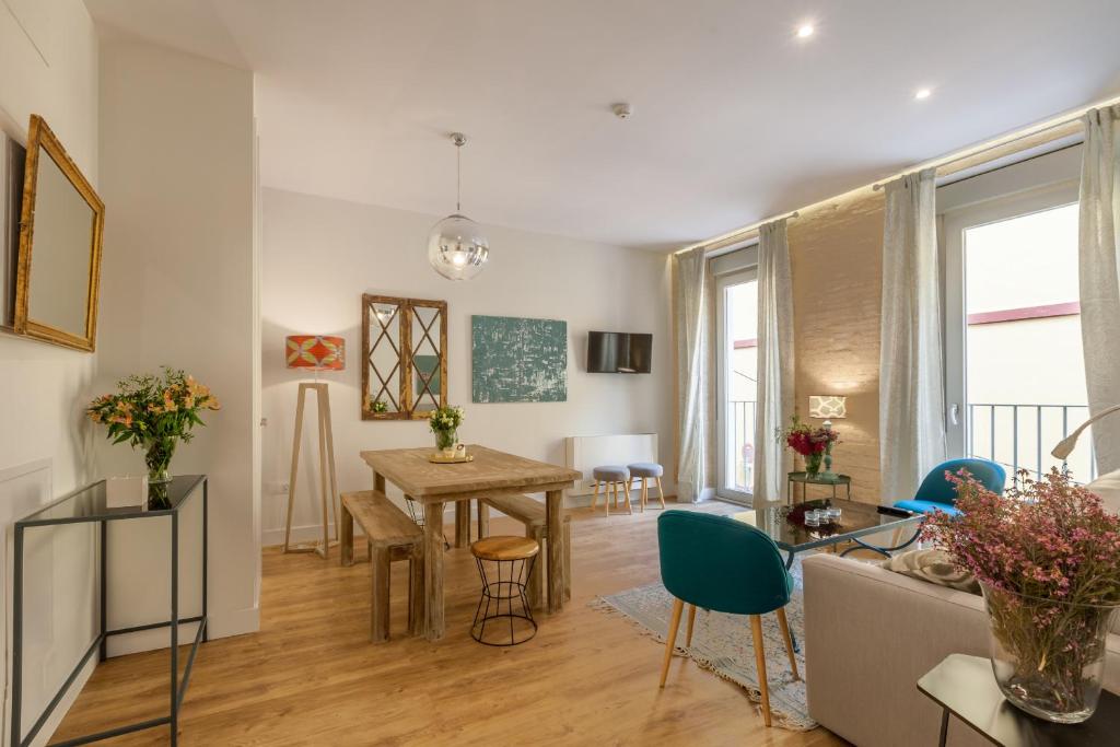 a living room with a table and a dining room at Apartamentos RG Suites Jardines de Murillo in Seville