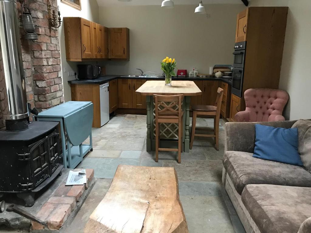 a living room with a couch and a table with a stove at Horseshoe Cottage in Belfast